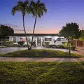 Front of the home at dusk, under the palm trees