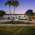 Front of the home at dusk, under the palm trees