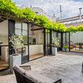 Cour pavée du bien, sous une pergola végétalisée
