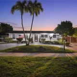 Front of the home at dusk, under the palm trees