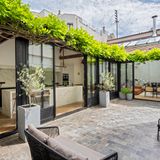 Cour pavée du bien, sous une pergola végétalisée