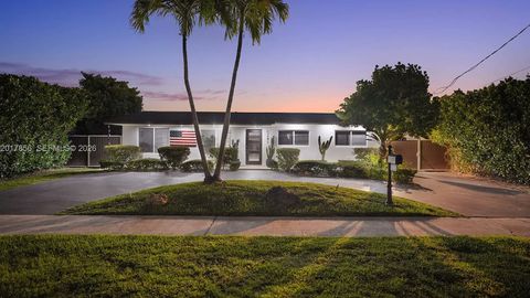 Front of the home at dusk, under the palm trees