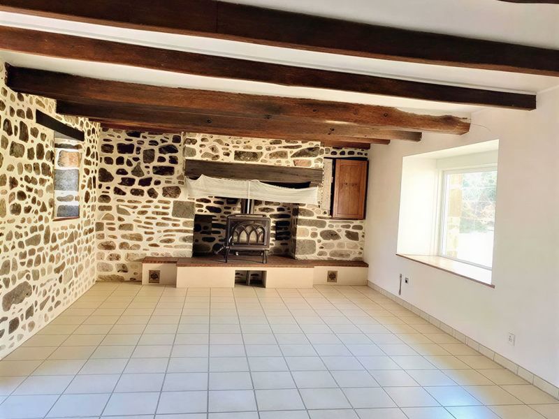 Living room with a stone fireplace, unfurnished